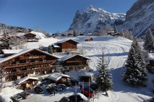 a ski lodge in the snow with a mountain at Alpenhof in Grindelwald