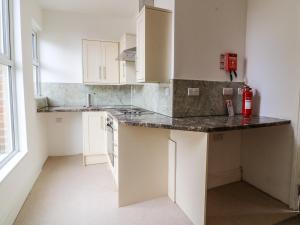 a kitchen with white cabinets and a black counter top at The Dukes Apartments, Flat 3 in Scarborough