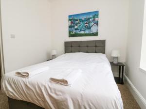 a bedroom with a white bed with two towels on it at The Dukes Apartments, Flat 3 in Scarborough