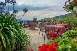 eine Terrasse mit Tischen, Stühlen und Blumen in der Unterkunft Panorama-Landgasthof Ranzinger in Schöfweg