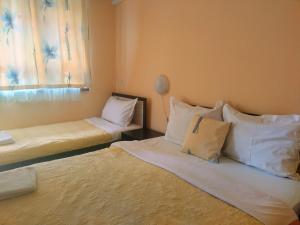 オブゾルにあるIvanka Guest Houseのベッド2台(白い枕付)、窓が備わる客室です。