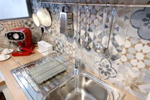 a kitchen sink with a dish drying rack above it at La Casetta delle Scienze in Palermo