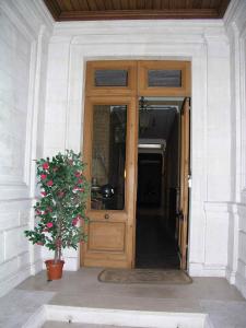 una puerta de madera con una planta delante en Château Rosemont - Grande maison familiale campagne dans le Médoc avec piscine et tennis à 15 mn Bordeaux en Labarde