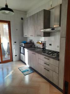 a kitchen with stainless steel appliances and a wooden floor at fronte mare in Giovinazzo