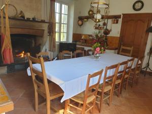 comedor con mesa, sillas y chimenea en Château Rosemont - Grande maison familiale campagne dans le Médoc avec piscine et tennis à 15 mn Bordeaux en Labarde