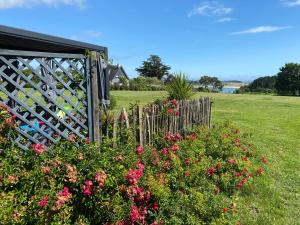 een tuin met roze bloemen en een houten hek bij Chambres d'Hôtes Bella Laïta in Keranquernat