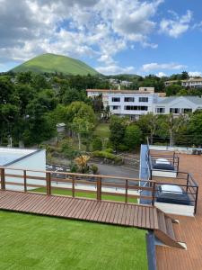 une terrasse en bois avec vue sur une maison dans l'établissement ISOLA Izukogen, à Itō