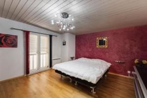1 dormitorio con cama y lámpara de araña en Grande villa indépendante, en Evionnaz