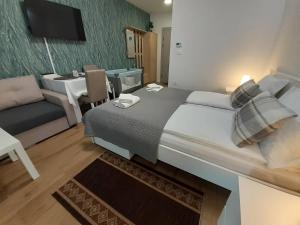 a bedroom with a large bed and a living room at Apartments Biro in Subotica