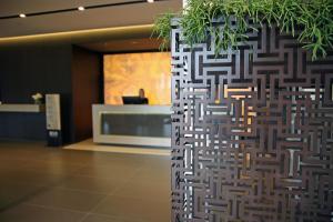 a wall in a lobby with a plant at Ego Hotel in Ancona