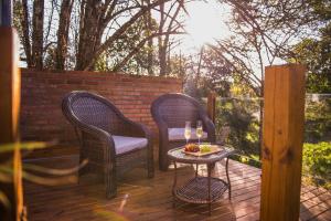 two chairs and a table with wine glasses on a deck at Loft Industrial 485 na Serra - Bento Gonçalves in Bento Gonçalves