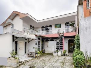 a house with white walls and pink accents at SPOT ON 91393 Budiluhur 10 Homestay in Bandung