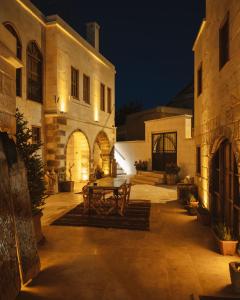 a picnic table in a courtyard of a building at night at Juno Cappadocia Adults Only in Uchisar