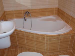 a bathroom with a tub and a toilet and a sink at Apartmán Janoušek in Humpolec