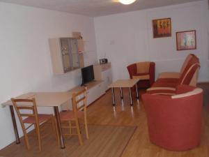 um quarto com uma mesa e cadeiras e uma televisão em Apartmán Janoušek em Humpolec