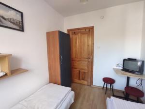 Habitación pequeña con cama y puerta de madera en Domki i pokoje blisko morza en Łeba