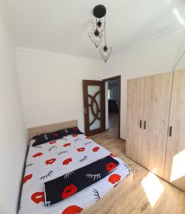 a bedroom with a bed with a comforter on it at Mountain View 2 - ciubar in Câmpulung