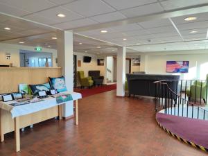 a hospital lobby with a couch and a piano at Hotel Mikligardur in Sauðárkrókur