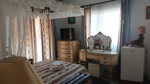 Schlafzimmer mit einem Bett, einer Kommode und einem Spiegel in der Unterkunft Greenfields Country Club in Limassol