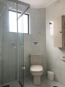 グアルジャにあるApto Astúrias Guarujáのバスルーム(トイレ、ガラス張りのシャワー付)