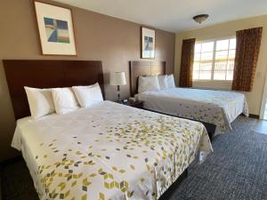 a hotel room with two beds and two windows at Beachway Inn in Arroyo Grande