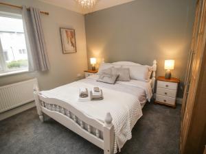 a bedroom with a white bed with two phones on it at Pebble Lodge in Kenmare