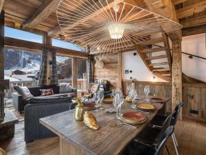 Un comedor con una gran mesa de madera en una casa. en Chalet de Luxe à Val d'Isère avec Jacuzzi et Hammam - FR-1-567-8, en Val dʼIsère