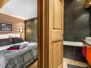 a bedroom with a bed and a bathroom with a tub at Appartement Val-d'Isère, 2 pièces, 4 personnes - FR-1-567-56 in Val-d'Isère