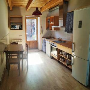 a kitchen with a table and a white refrigerator at Casa Alejandra in Murchante