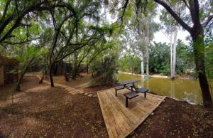 a picnic table sitting on a wooden platform next to a river at Vulture's View 7 in Pretoria