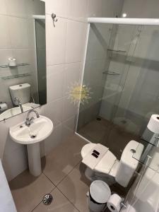 a bathroom with a shower and a toilet and a sink at Residencial Solariun Ilhabela in Ilhabela