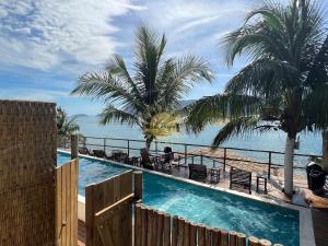 a swimming pool with a view of the ocean at Residencial Solariun Ilhabela in Ilhabela