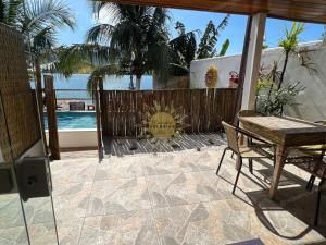 d'une terrasse avec une table, des chaises et une clôture. dans l'établissement Residencial Solariun Ilhabela, à Ilhabela