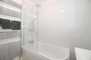 a white bathroom with a shower and a sink at Exmouth - Newly available, near the Beach in Exmouth