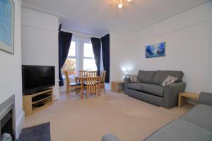 a living room with a couch and a tv at Exmouth - Newly available, near the Beach in Exmouth