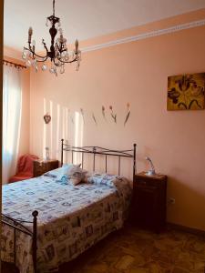 a bedroom with a bed and a chandelier at Casa Viola in Diano Marina