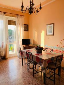 a dining room with a table and chairs and a television at Casa Viola in Diano Marina