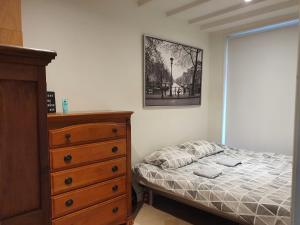 a bedroom with a bed and a dresser and a window at Appartement in Stadsdeel West in Amsterdam