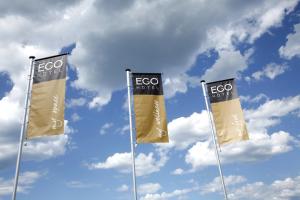 three flags on poles in front of a cloudy sky at Ego Hotel in Ancona