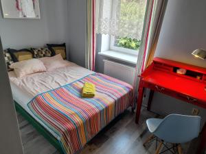 a small bedroom with a bed and a desk at Silver Wolf Bosacka in Krakow