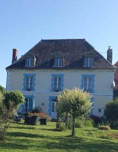 una casa bianca con un albero davanti di Maison Du Cheval a Chalais