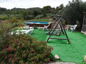 a playground with a swing and a boat in a yard at MAS GUILLO in San Quintín de Mediona