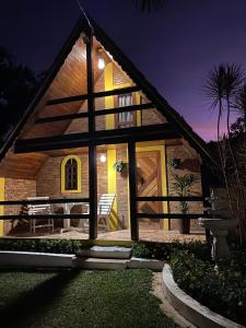 una casa con techo de paja por la noche en Chalé Bela Vista, en Areias