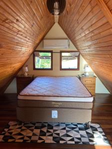 ein großes Bett in einem Zimmer mit Holzdecke in der Unterkunft Chalé Bela Vista in Areias