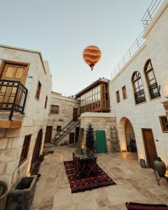 a hot air balloon is flying over a building at Juno Cappadocia Adults Only in Uçhisar