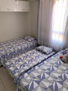 2 łóżka pojedyncze w pokoju z oknem w obiekcie Praia e Sol Apto a 3 quadras do Bessa Beach. w mieście João Pessoa