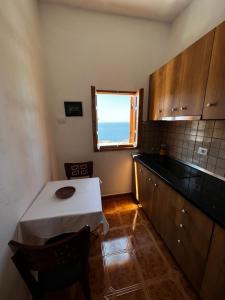 a small kitchen with a table and a window at Traditional old house in Dhërmi
