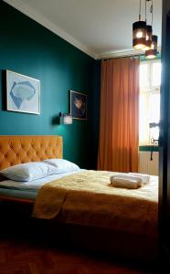 Old Town Plus في تارنوف: غرفة نوم بها سرير وبجدران خضراء ونافذة