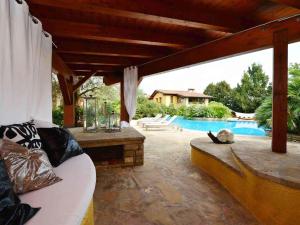 a patio with a couch and a swimming pool at Doremi BB Foresteria in Desenzano del Garda