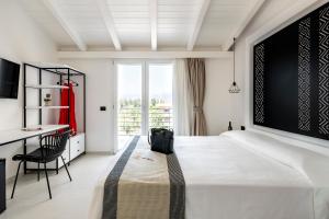 een witte slaapkamer met een groot bed en een bureau bij Cara a Bentu - Charming Rooms in Tortolì